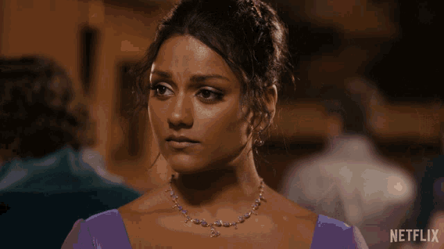 a woman in a purple dress with a netflix logo on the bottom right