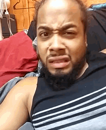 a man with a beard is making a funny face in bed