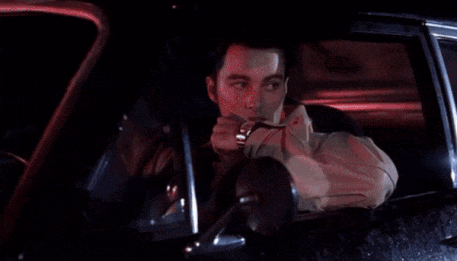 a man is sitting in a car with his hand on his face