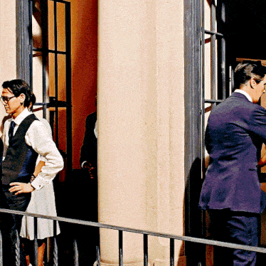 a man in a purple suit stands next to a woman