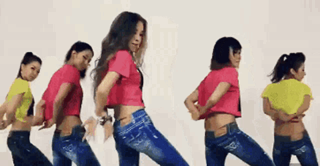 a group of young women are dancing together in a line