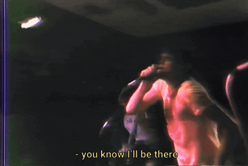 a man singing into a microphone with the words you know i 'll be there above him
