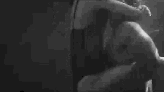 a black and white photo of a man and a woman kissing underwater .