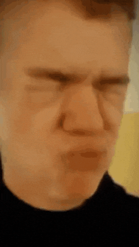 a close up of a man making a funny face .