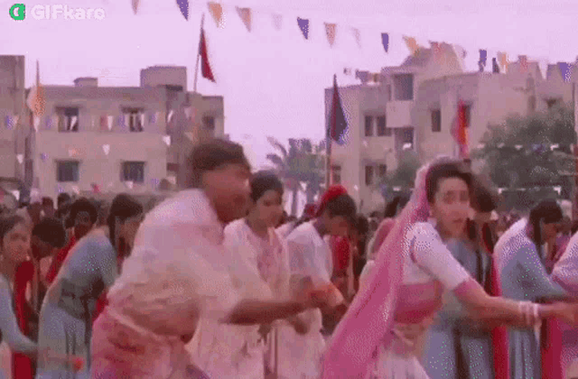 a group of people are dancing in front of a building in a crowd .
