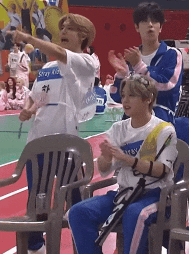 a man wearing a shirt that says stray kid is clapping his hands