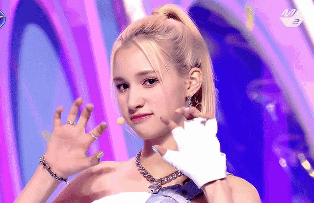 a woman wearing a ponytail and white gloves waves at the camera