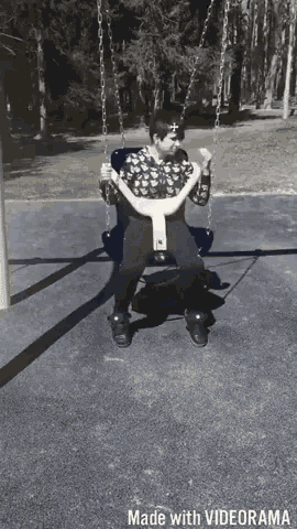 a black and white photo of a person sitting on a swing made by videorama