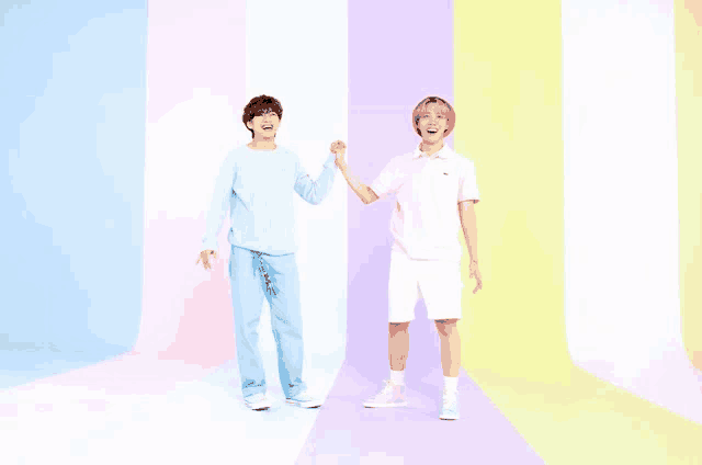 two men are standing next to each other holding hands