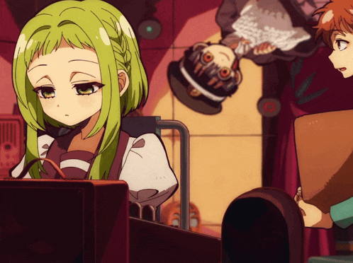 a girl with green hair is sitting in front of a computer monitor
