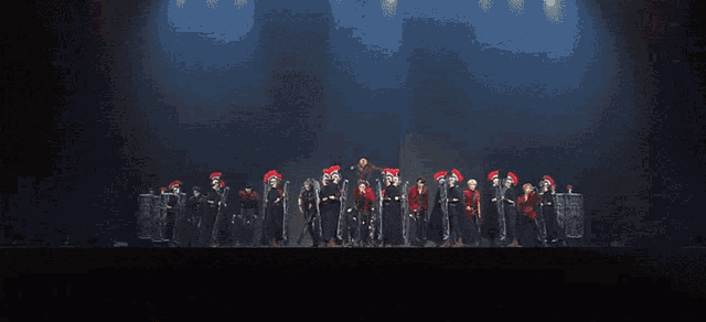 a group of people are standing on a stage with shields