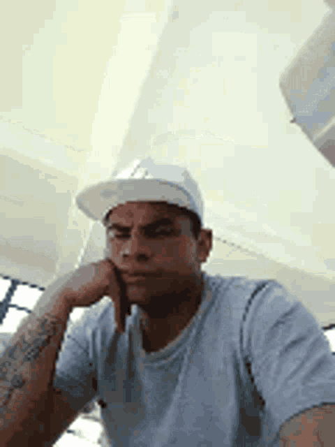 a man wearing a baseball cap and a t-shirt is taking a selfie .