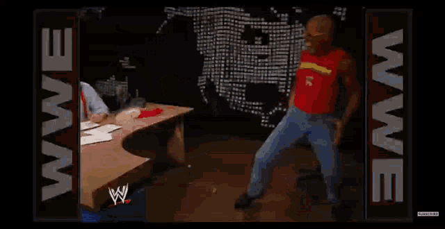 a man is laying on the floor next to a wwe logo