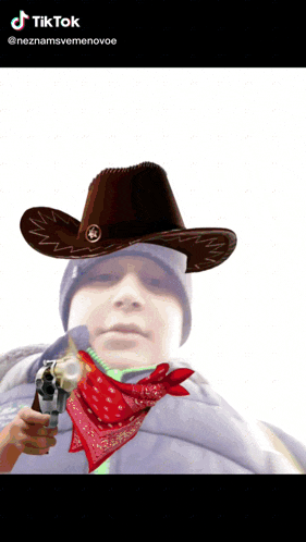 a man wearing a cowboy hat and a red bandana holds a gun