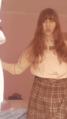 a girl wearing a plaid skirt and a teddy bear sweater
