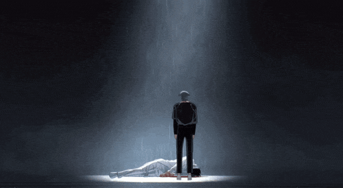 a man standing next to a man laying on the floor