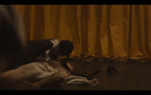 a blurry picture of a person laying on a bed with a yellow curtain behind them