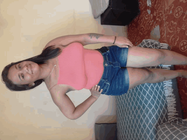 a woman wearing shorts and a pink tank top smiles