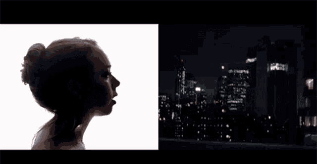 a silhouette of a woman looking out a window at night