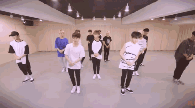 a group of young men are standing in a dance studio and one of them is wearing a supreme shirt