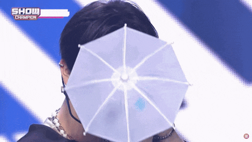 a man is holding a small white umbrella in front of his face .