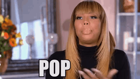 a woman in a black turtleneck is making a funny face and says pop