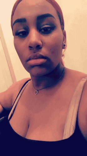 a woman taking a selfie with a heart necklace