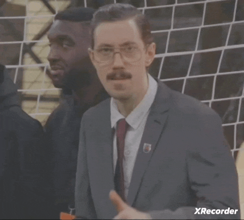a man in a suit and tie giving a thumbs up with xrecorder in the corner
