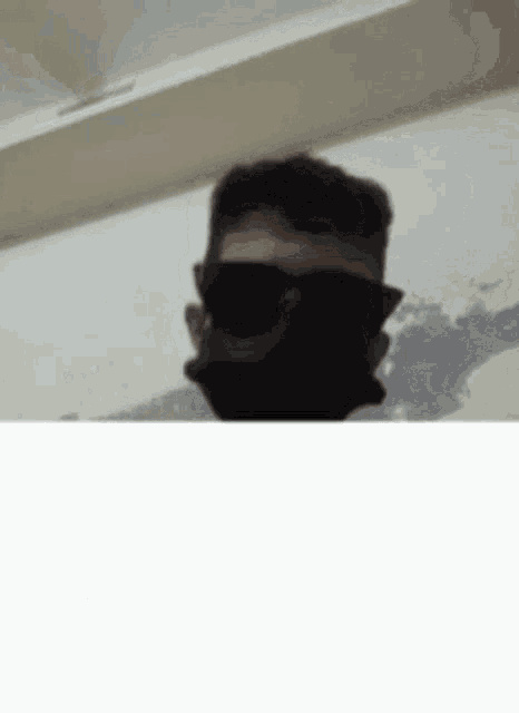 a man wearing sunglasses and a mask on his face .