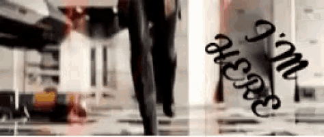 a blurry picture of a person walking in a room with graffiti on the wall