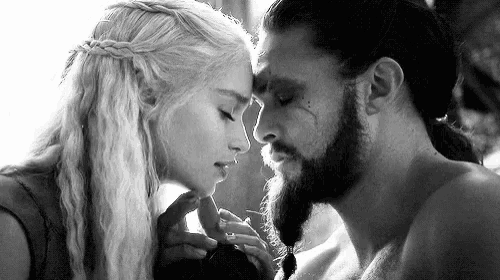 a black and white photo of a man and woman kissing .