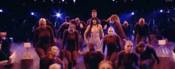 a group of people are dancing on a stage with the word live on the bottom right
