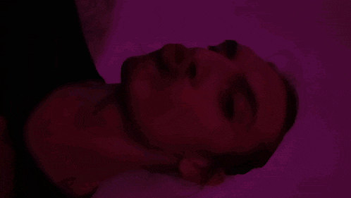 a close up of a woman 's face against a pink background
