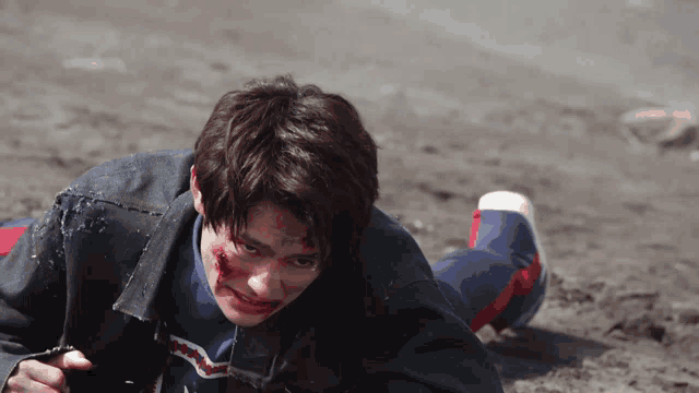 a man laying on the ground with blood on his face wearing a levis shirt