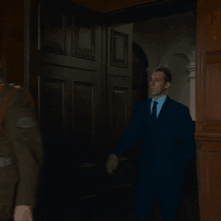 a man in a suit and tie is standing in a dark room
