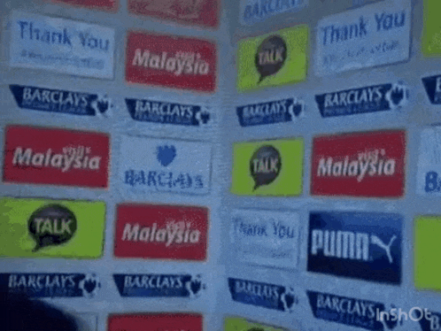 a man in a suit says could care less in front of a wall of advertisements