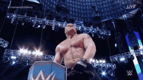 a shirtless wrestler stands in front of a sign that says ' lesnar vs goldberg ' on it