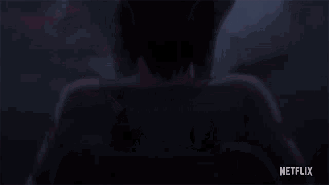 a person is standing in the dark with a netflix logo on the bottom .
