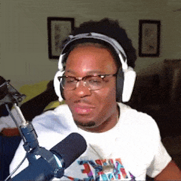 a man wearing glasses and headphones is sitting in front of a microphone .