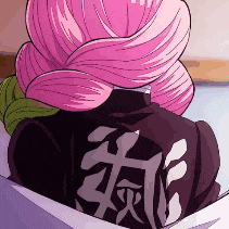 a person with pink hair is sitting in a box with a black shirt on .