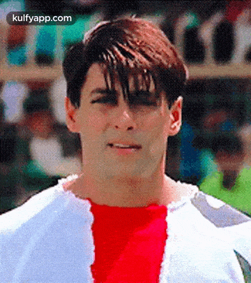 a close up of a man wearing a white shirt and a red shirt with a hole in it .