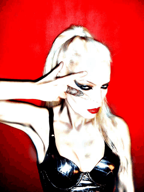 a woman in a black bra is making a peace sign with her hands