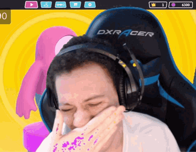 a man wearing headphones is sitting in a dxracer gaming chair
