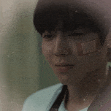 a man with a bandage on his face looks sad