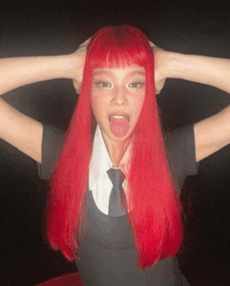 a woman with red hair is sticking her tongue out and making a funny face