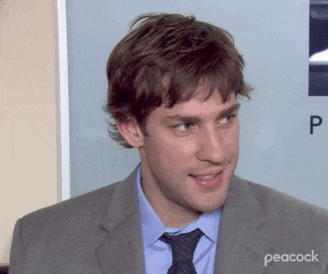 a man in a suit and tie is smiling in front of a sign that says peacock
