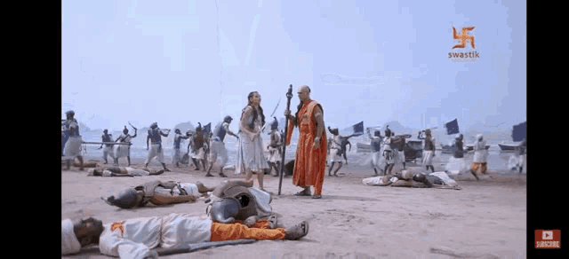 a man in a red robe stands in front of a group of people laying on the ground