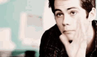 a man is sitting at a table with his hand on his chin .