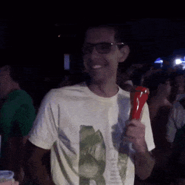a man wearing glasses is holding a red object