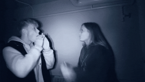 a man smoking a cigarette next to a woman